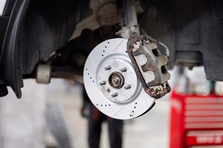 Bremsenservice mit perforierte Bremsscheiben und neue Bremsbeläge.