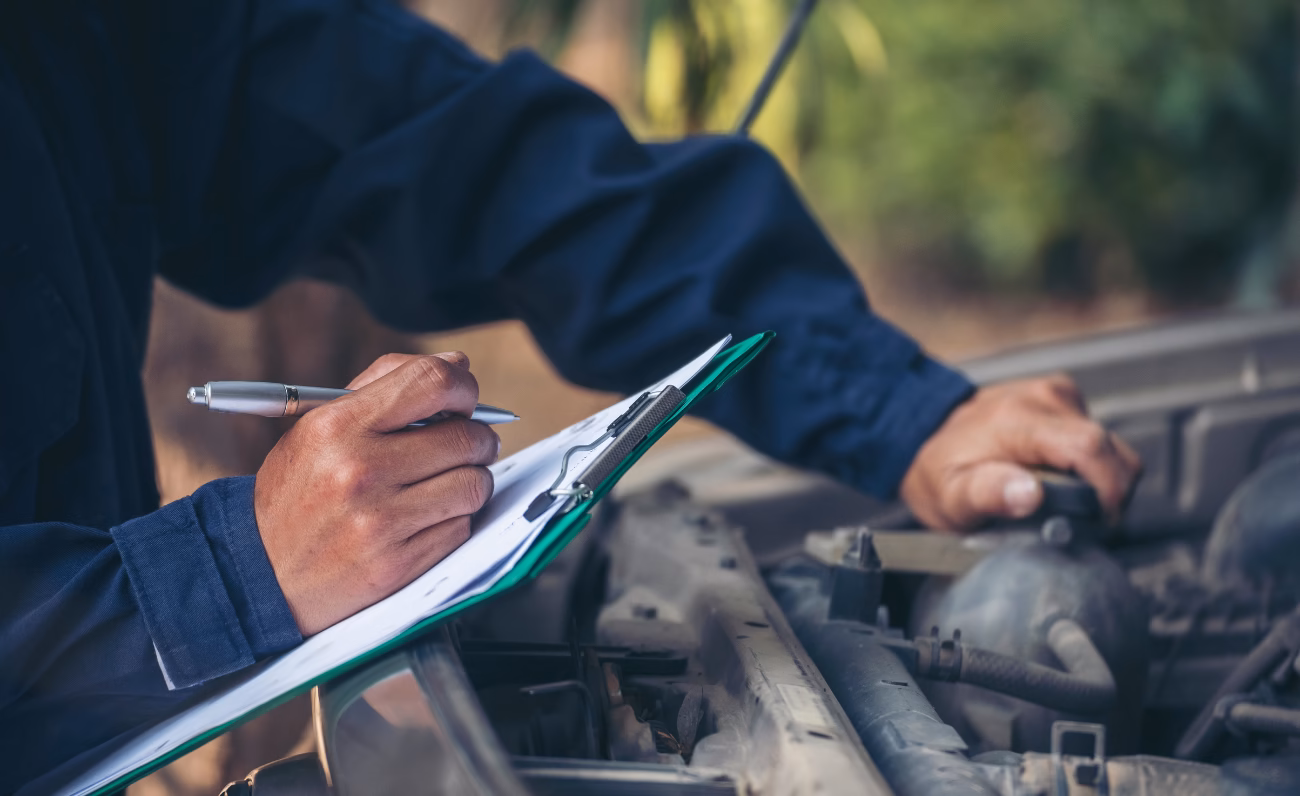 Mechaniker dokumentiert Fahrzeugdaten für Gutachter, Versicherung und mögliche Direktverrechnung nach einem Autoschaden